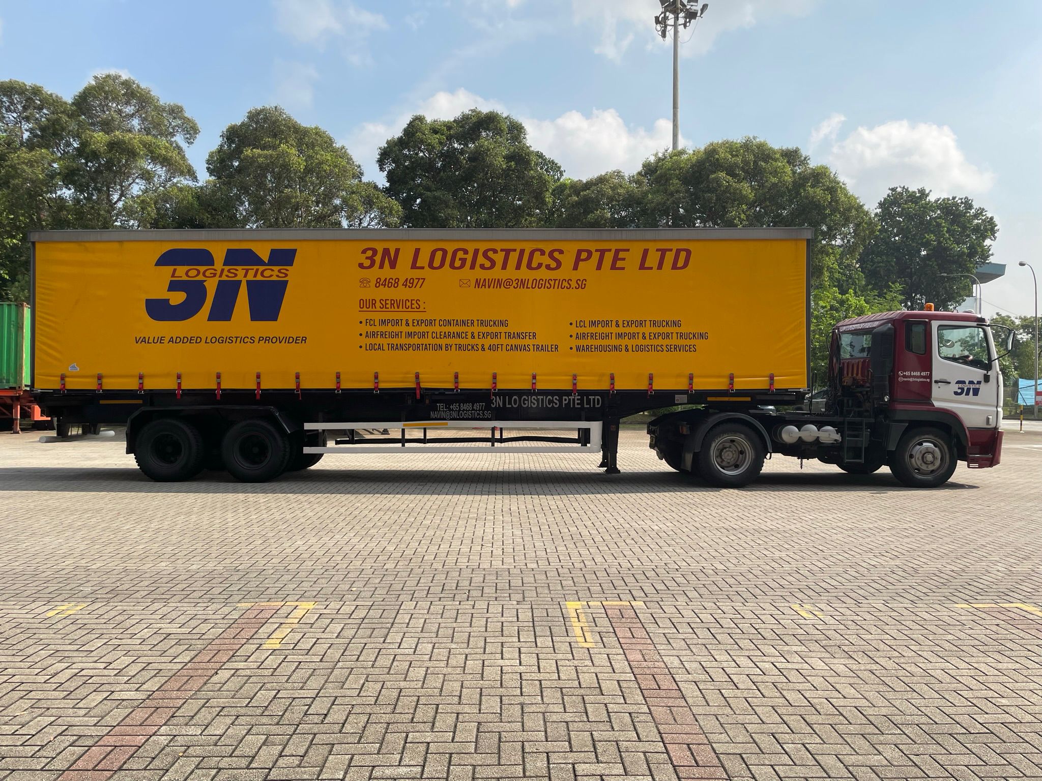 3N Logistics yellow canvas truck at outdoor port yard